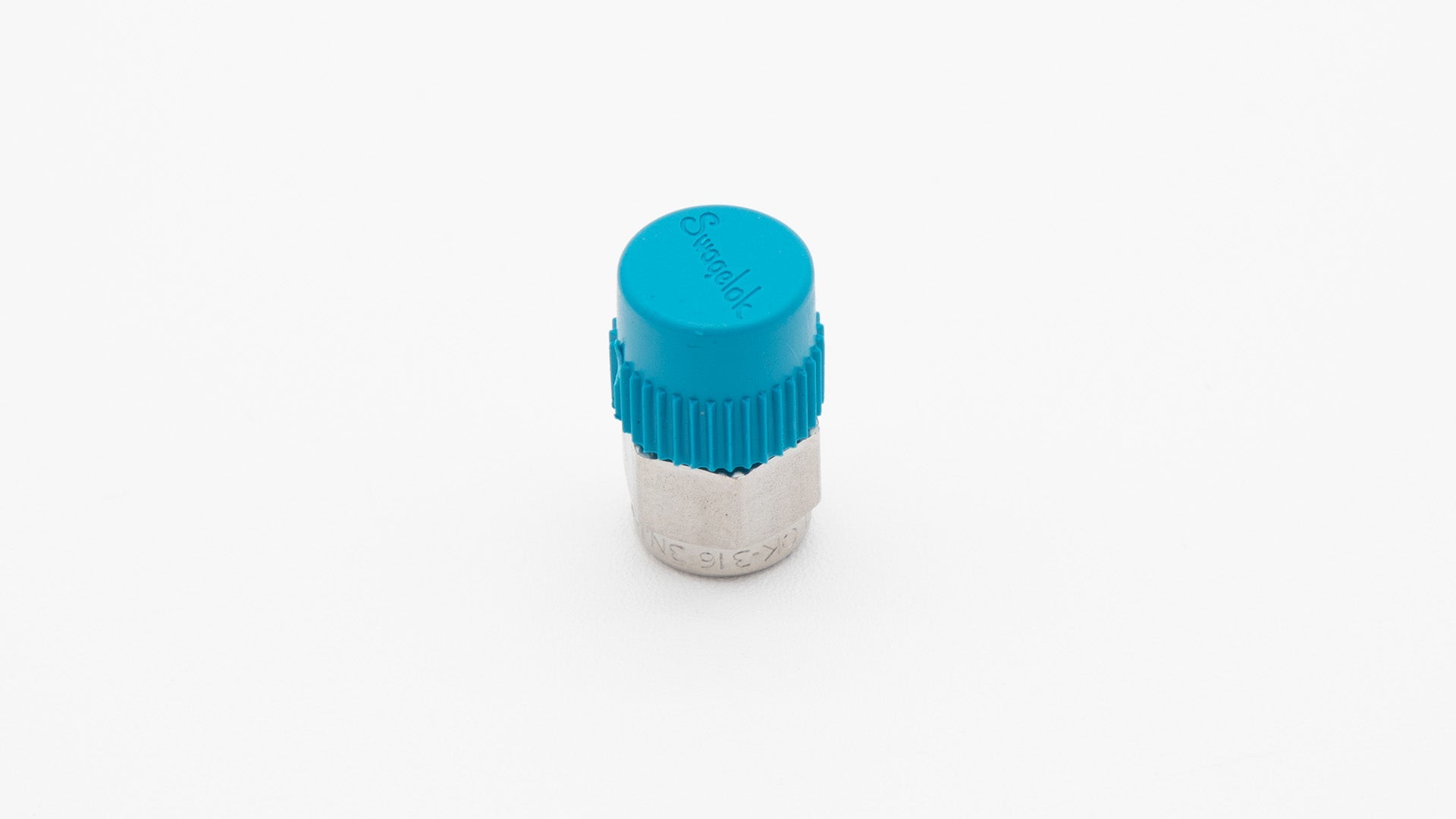 A blue plastic threaded fitting placed on a clean white surface, showcasing its design and color contrast.