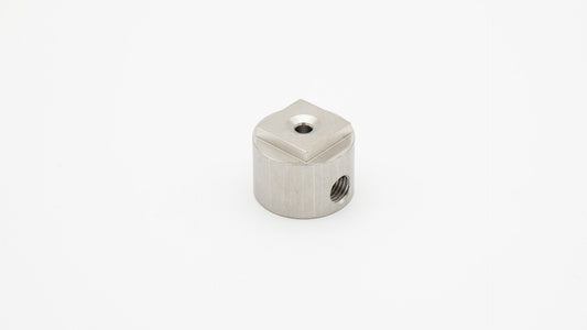 Cylindrical piece with threaded ports and square top.